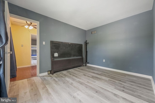 unfurnished living room featuring wood finished floors, a ceiling fan, and baseboards