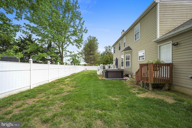 view of yard with a hot tub and a wooden deck