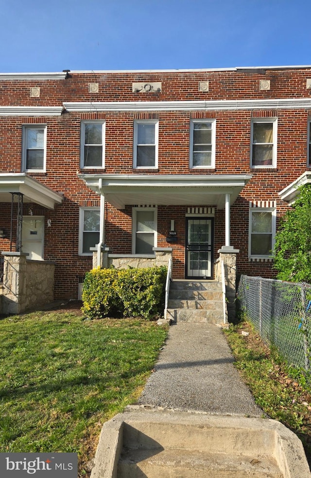 townhome / multi-family property featuring brick siding and fence