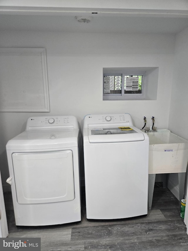 washroom with washer and clothes dryer and wood finished floors