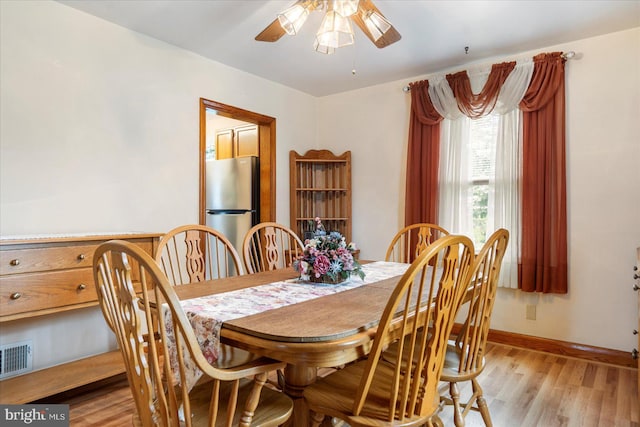 dining room with ceiling fan, light wood-type flooring, and baseboards