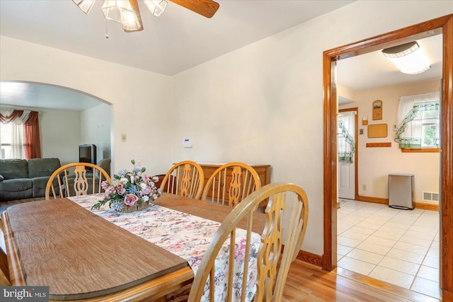 dining area with arched walkways, healthy amount of natural light, ceiling fan, and baseboards