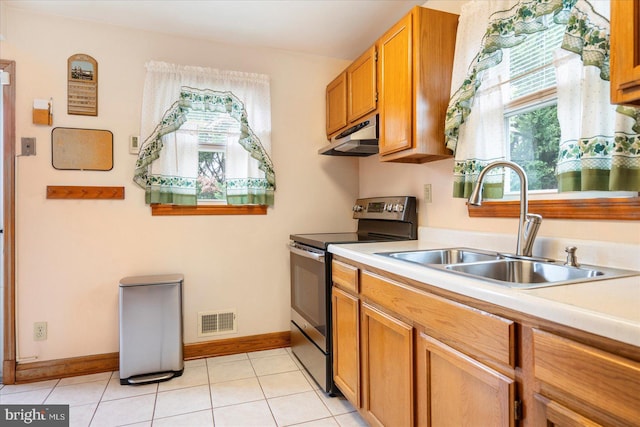 kitchen with stainless steel electric range oven, under cabinet range hood, light countertops, and healthy amount of natural light