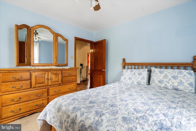 bedroom featuring arched walkways and a ceiling fan