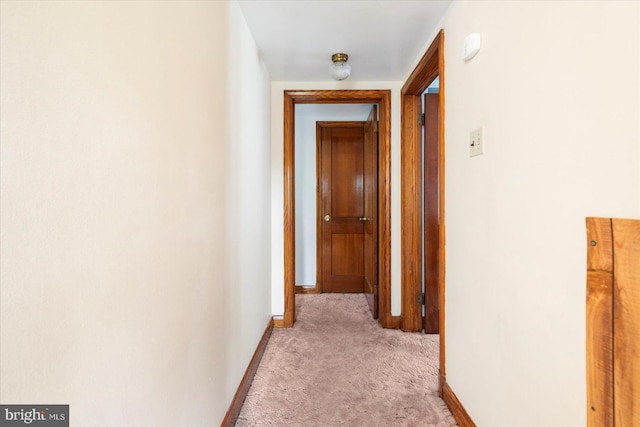 corridor with light carpet and baseboards
