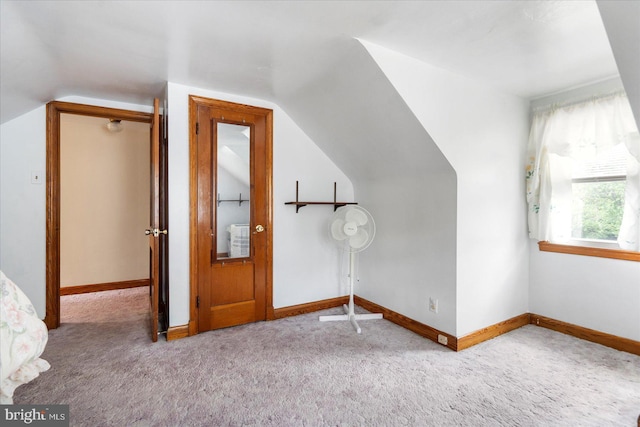 additional living space featuring carpet floors, vaulted ceiling, and baseboards