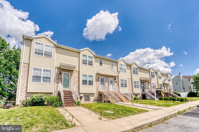 multi unit property with a residential view, brick siding, and a front yard