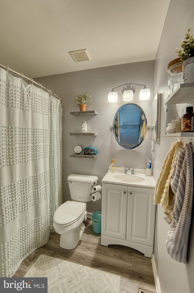 bathroom with wood finished floors, toilet, baseboards, and vanity