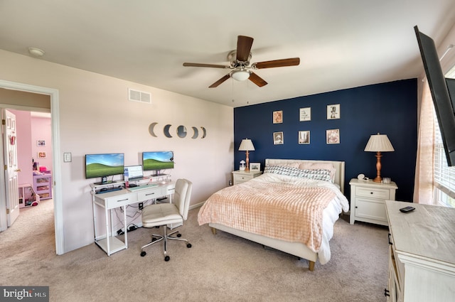 carpeted bedroom with ceiling fan and a desk