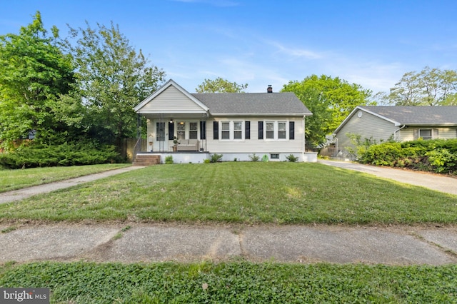 single story home featuring a porch, a chimney, a front yard, and roof with shingles