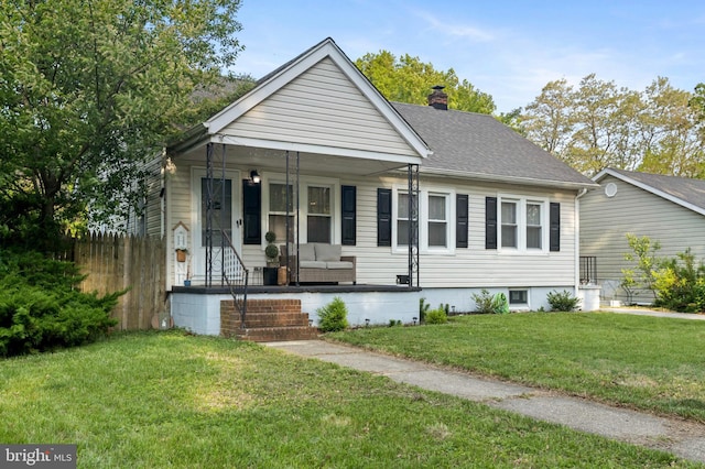 view of front of property featuring covered porch, a chimney, and a shingled roof