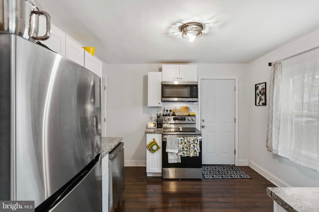 kitchen with appliances with stainless steel finishes, baseboards, and dark wood finished floors