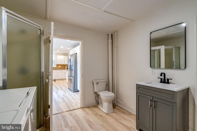 full bathroom with wood finished floors, toilet, vanity, and a shower with door