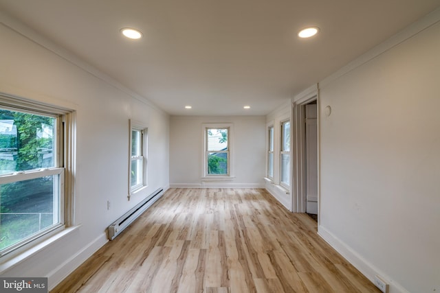 spare room featuring baseboard heating, plenty of natural light, light wood-style floors, recessed lighting, and ornamental molding