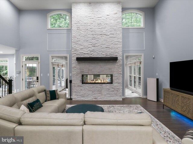 8197 Cottage Rose Ct, Fairfax Station, VA 22039 - living room with wood finished floors, a high ceiling, a fireplace, and baseboards
