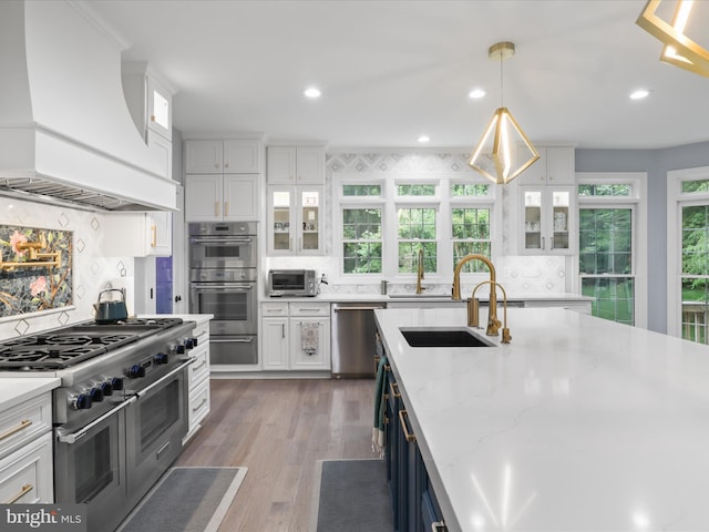 8197 Cottage Rose Ct, Fairfax Station, VA 22039 - kitchen featuring premium range hood, stainless steel appliances, a sink, white cabinetry, and recessed lighting