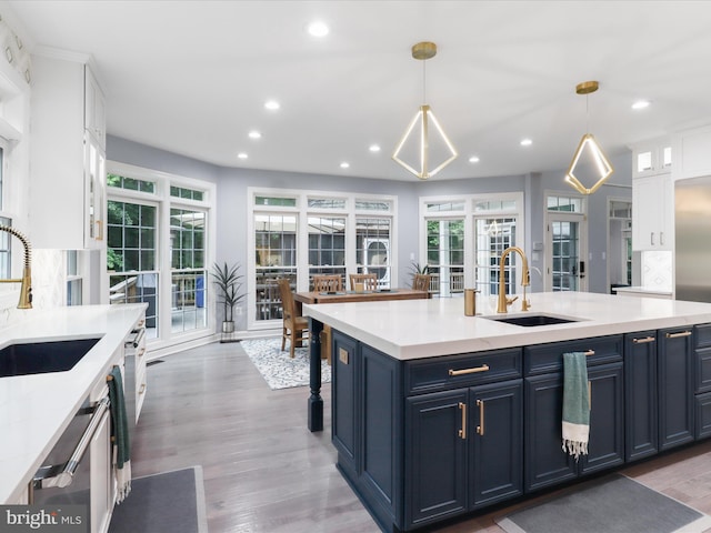 8197 Cottage Rose Ct, Fairfax Station, VA 22039 - kitchen featuring a sink, recessed lighting, blue cabinets, and light wood finished floors
