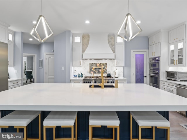 8197 Cottage Rose Ct, Fairfax Station, VA 22039 - kitchen with custom exhaust hood, stainless steel appliances, white cabinets, glass insert cabinets, and tasteful backsplash