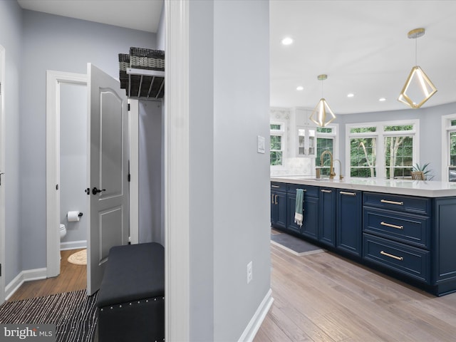 8197 Cottage Rose Ct, Fairfax Station, VA 22039 - bar with a sink, light wood-style flooring, baseboards, recessed lighting, and hanging light fixtures