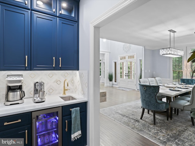 8197 Cottage Rose Ct, Fairfax Station, VA 22039 - indoor wet bar featuring beverage cooler, backsplash, healthy amount of natural light, and wood finished floors