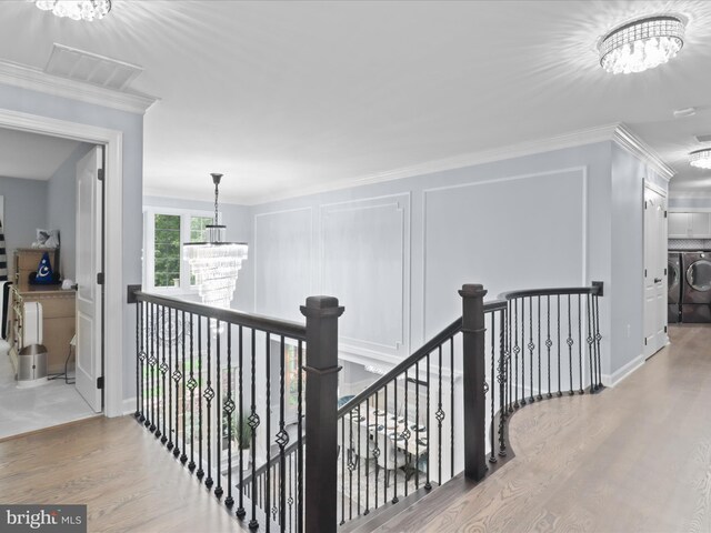 8197 Cottage Rose Ct, Fairfax Station, VA 22039 - hall with a chandelier, washing machine and dryer, an upstairs landing, wood finished floors, and ornamental molding