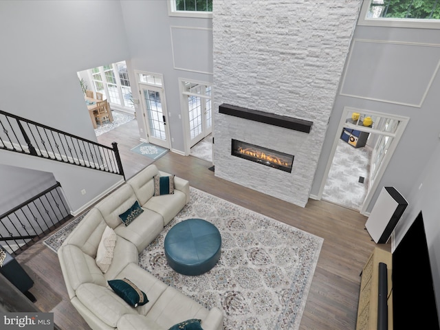8197 Cottage Rose Ct, Fairfax Station, VA 22039 - living room with healthy amount of natural light, a towering ceiling, a fireplace, wood finished floors, and baseboards