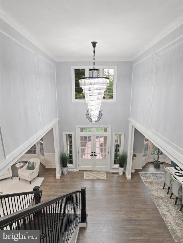 8197 Cottage Rose Ct, Fairfax Station, VA 22039 - living room featuring a chandelier, french doors, wood finished floors, a decorative wall, and crown molding