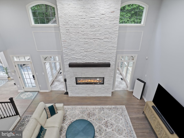 8197 Cottage Rose Ct, Fairfax Station, VA 22039 - living room featuring wood finished floors, a high ceiling, a fireplace, and healthy amount of natural light