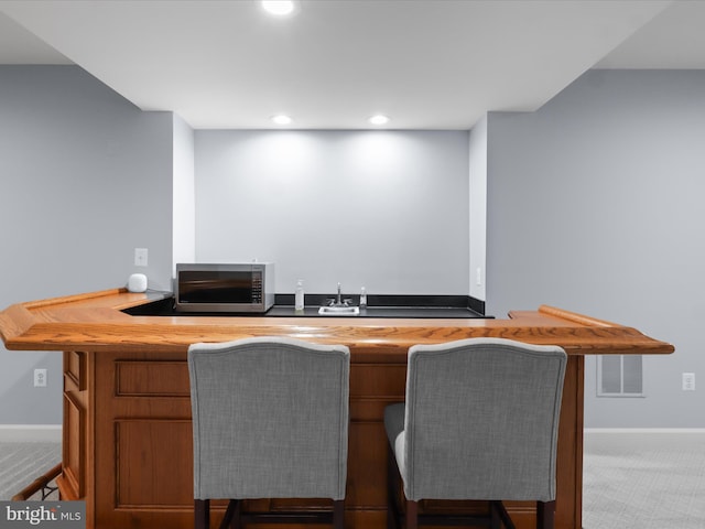 8197 Cottage Rose Ct, Fairfax Station, VA 22039 - indoor wet bar featuring stainless steel microwave, baseboards, carpet floors, and recessed lighting