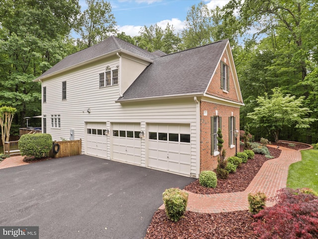 8197 Cottage Rose Ct, Fairfax Station, VA 22039 - view of side of property featuring roof with shingles, driveway, brick siding, and a garage