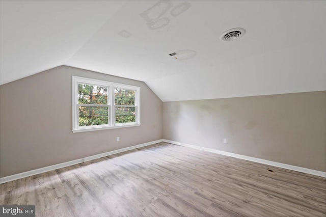 bonus room with wood finished floors, vaulted ceiling, and baseboards