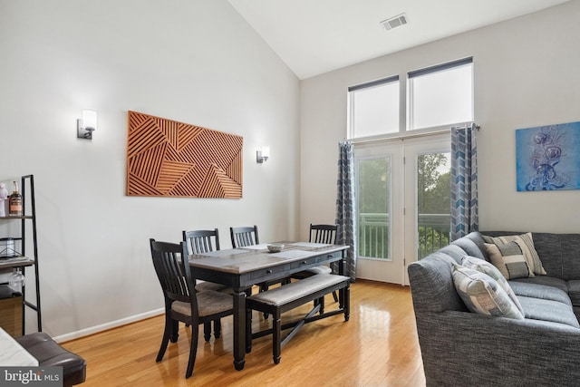 12001 Market St Unit 441, Reston, VA 20190 - dining area with high vaulted ceiling, light wood-type flooring, and baseboards