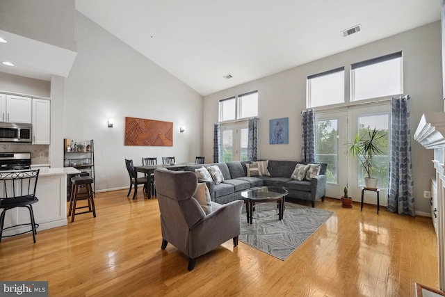 12001 Market St Unit 441, Reston, VA 20190 - living area with high vaulted ceiling, light wood-style floors, and baseboards