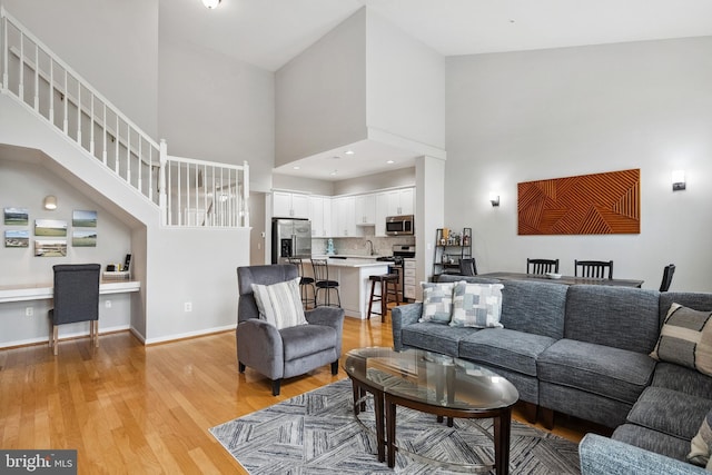 12001 Market St Unit 441, Reston, VA 20190 - living area featuring light wood finished floors, a high ceiling, an office area, and stairs
