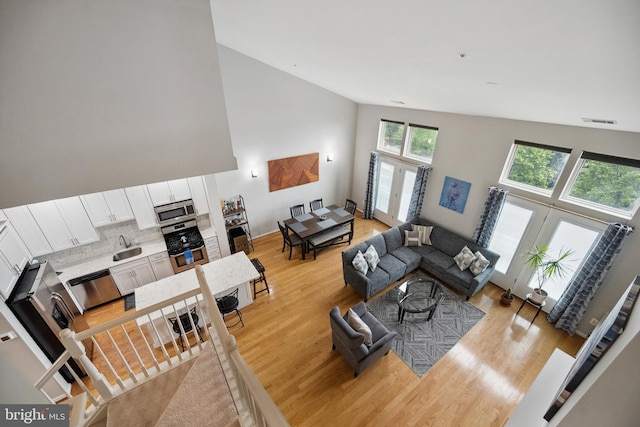 12001 Market St Unit 441, Reston, VA 20190 - living room featuring light wood-type flooring, high vaulted ceiling, and french doors