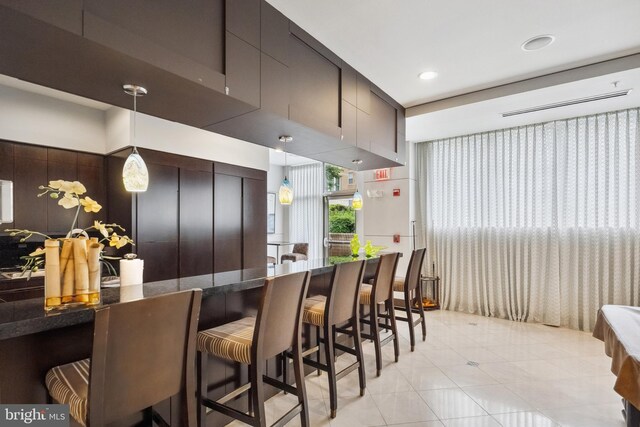 12001 Market St Unit 441, Reston, VA 20190 - kitchen featuring hanging light fixtures, a breakfast bar area, modern cabinets, dark stone counters, and recessed lighting