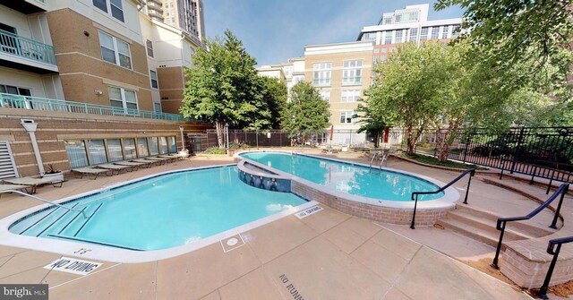 12001 Market St Unit 441, Reston, VA 20190 - community pool with fence, a hot tub, and a patio area