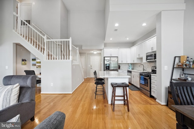 12001 Market St Unit 441, Reston, VA 20190 - kitchen featuring stainless steel appliances, open floor plan, a kitchen bar, white cabinetry, and a sink