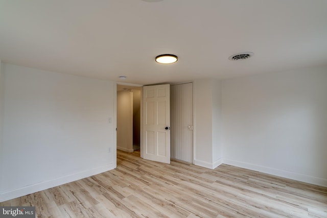 spare room featuring light wood finished floors and baseboards