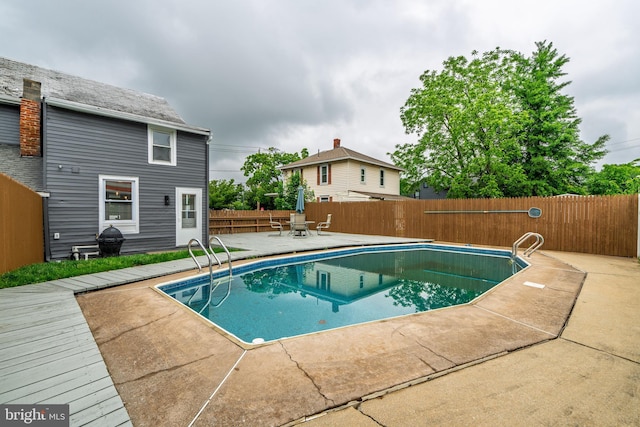 view of swimming pool featuring a fenced backyard, a patio, and area for grilling