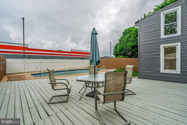 deck featuring a fenced backyard and outdoor dining area
