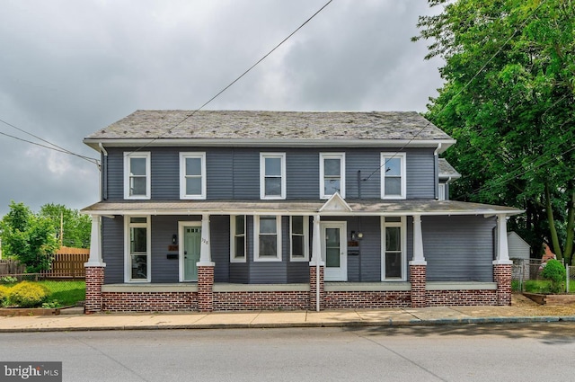 view of front facade with a porch and fence
