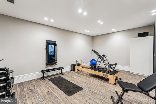 exercise room with wood finished floors, baseboards, and recessed lighting