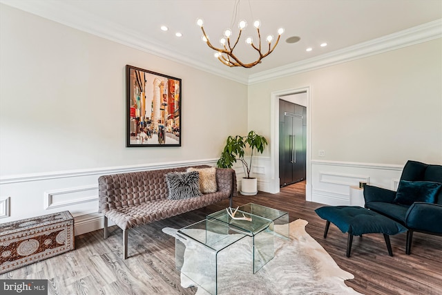 living area with a chandelier, crown molding, wainscoting, wood finished floors, and recessed lighting
