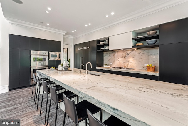kitchen featuring open shelves, a sink, built in appliances, dark cabinets, and modern cabinets