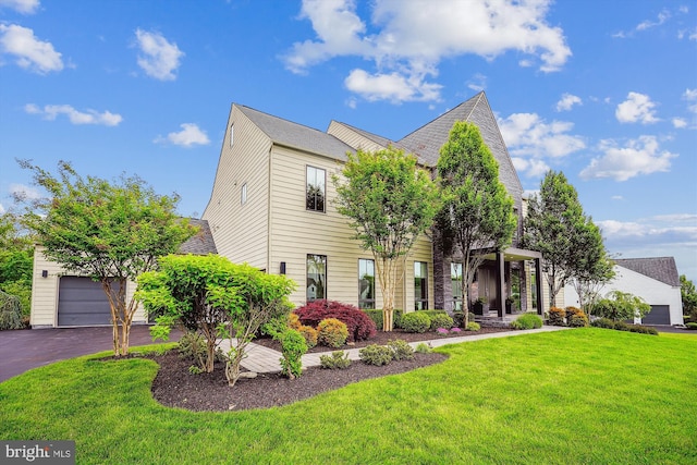view of front of home with a front lawn, a garage, and driveway