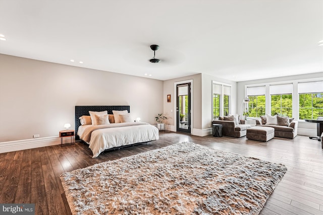 bedroom with access to outside, multiple windows, wood-type flooring, baseboards, and recessed lighting