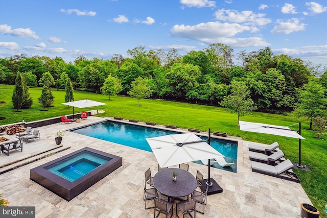 swimming pool with an in-ground hot tub, a yard, a patio area, and view of wooded area