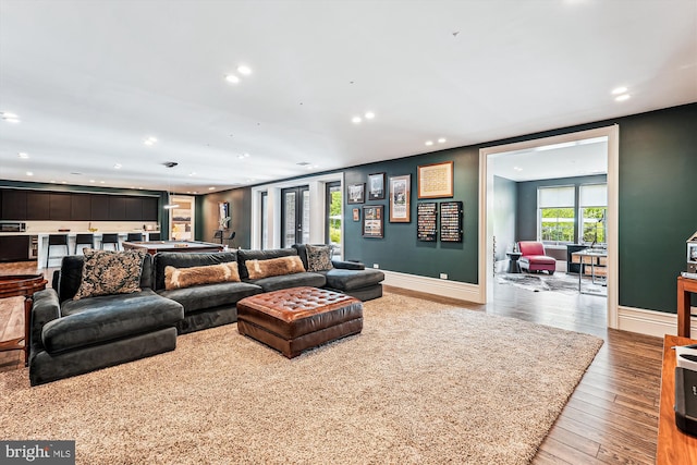 living room with recessed lighting, hardwood / wood-style flooring, and baseboards