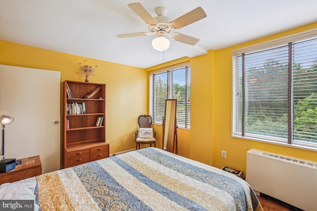 bedroom with radiator heating unit and ceiling fan